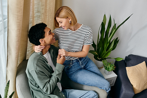 A young multicultural couple enjoys a cozy moment together in their modern apartment.