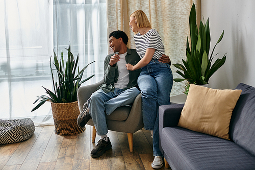 A young interracial couple enjoys a relaxing afternoon together in their modern apartment.