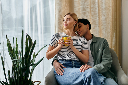 A young, multicultural couple relax together in a modern apartment, enjoying a quiet afternoon.