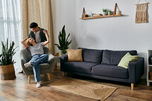 A young, multicultural couple enjoys a relaxing afternoon together in their modern apartment.