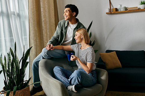 A young multicultural couple relaxes in their modern apartment, enjoying each others company.