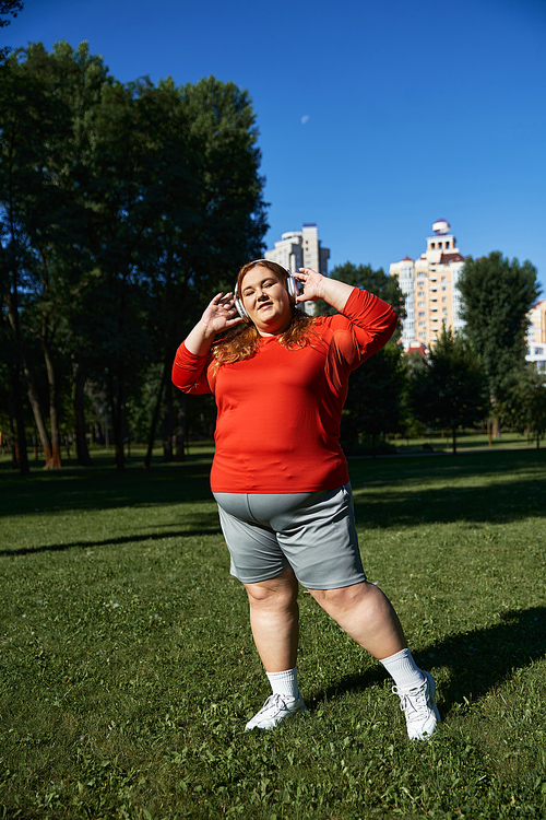 A beautiful woman engages in fitness amidst lush greenery and sunny skies.