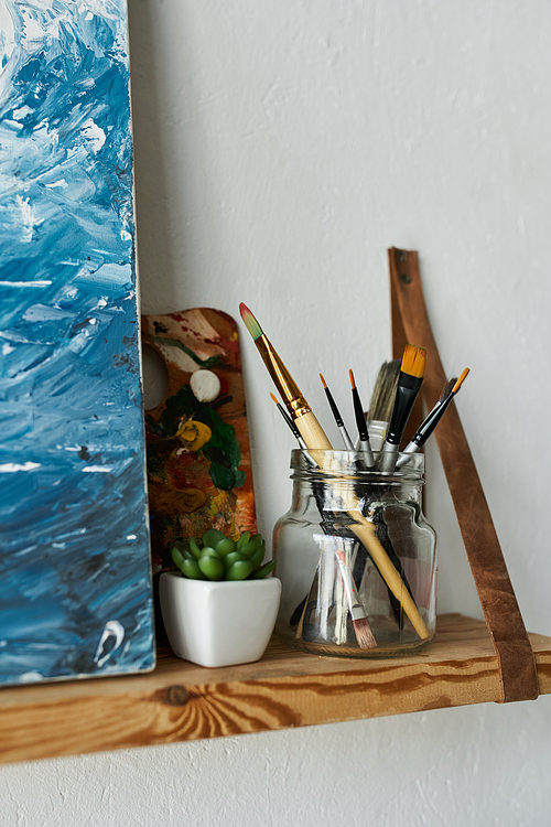 Brushes near painting in studio.