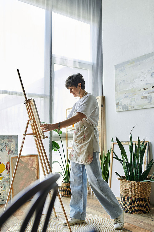 A talented woman passionately creates her artwork in a bright, inspiring studio.