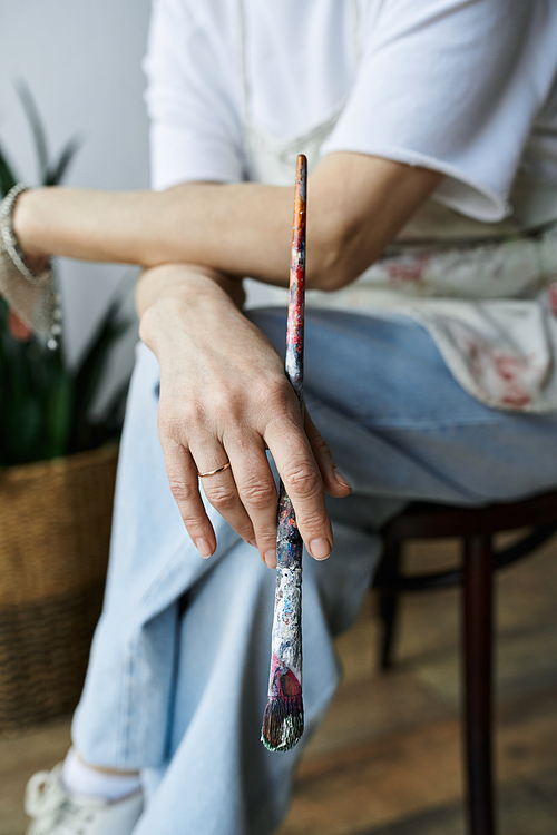 A painter reflects on her artistic journey while holding a brush.