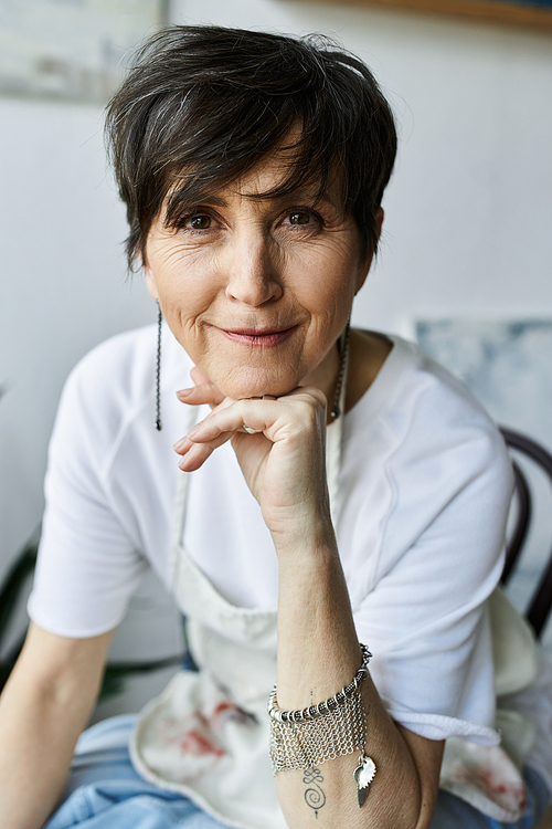 A mature woman enjoys her time in the art studio, expressing creativity.