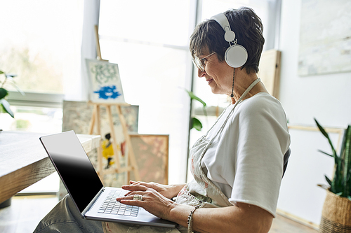 A woman engages with her creative process in a sunny art studio.