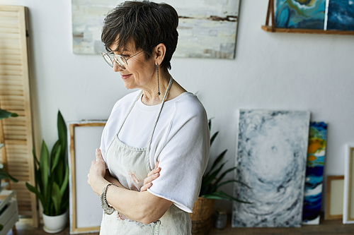 A contemplative artist enjoying her creative space and artwork.