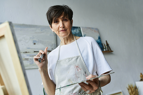 A passionate painter engages with her artwork in an inspiring studio.