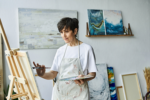 A woman joyfully creates art in her inviting studio space.