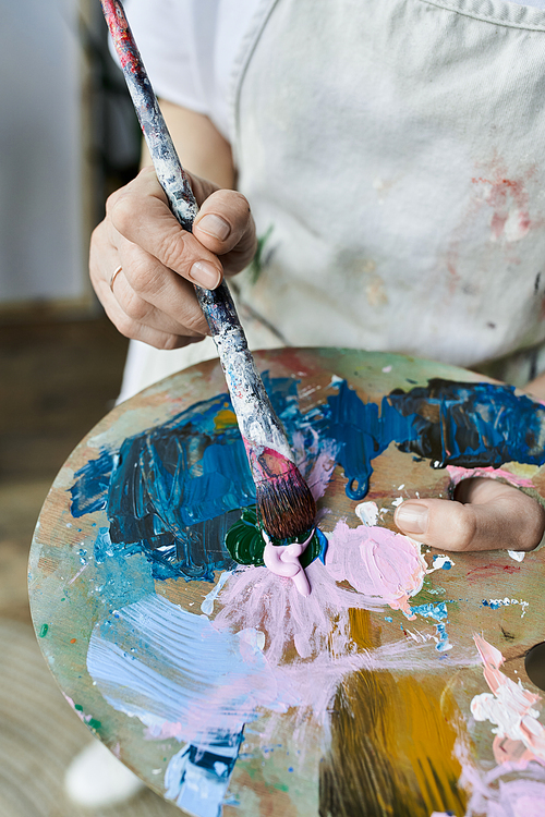 A dedicated painter blends vibrant colors on her palette with an artistic touch.