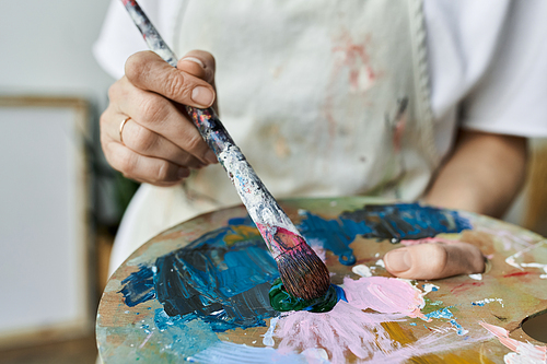 A passionate artist mixes vibrant colors on her palette.