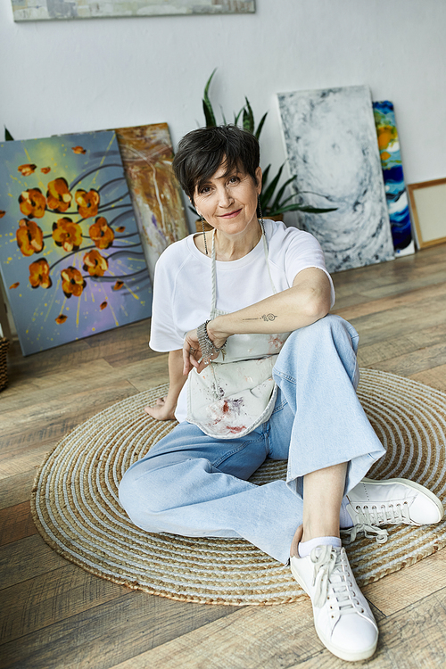 A painter relaxes in her studio, surrounded by her vibrant artwork.