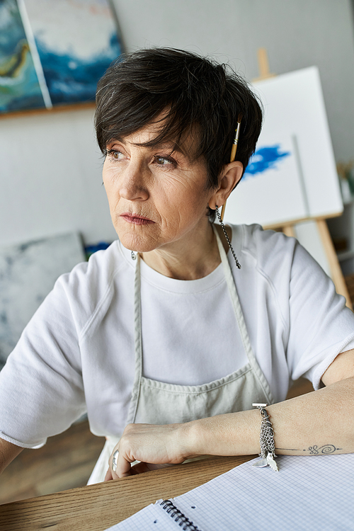 A dedicated artist deeply focused on her latest project in an inspiring studio.