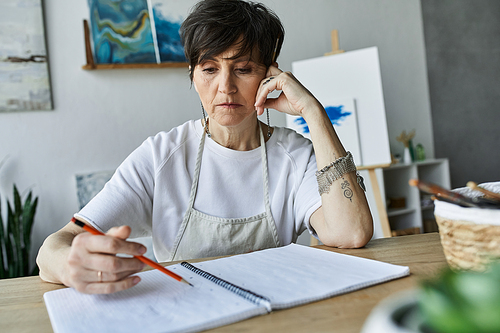 A focused artist sketches ideas in her serene art studio.