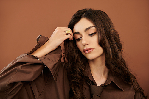 A confident young woman poses gracefully, showcasing her chic autumn ensemble amidst a cozy studio backdrop.