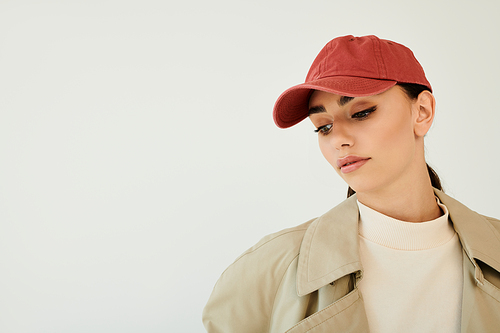 A young woman poses gracefully in a fashionable autumn outfit, embodying seasonal style in a modern studio ambiance.