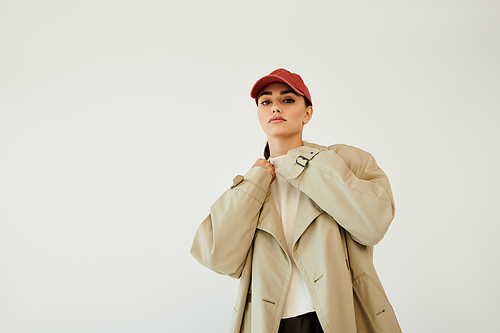 A young woman showcases her autumn style with a chic outfit, exuding confidence in a cozy studio environment.