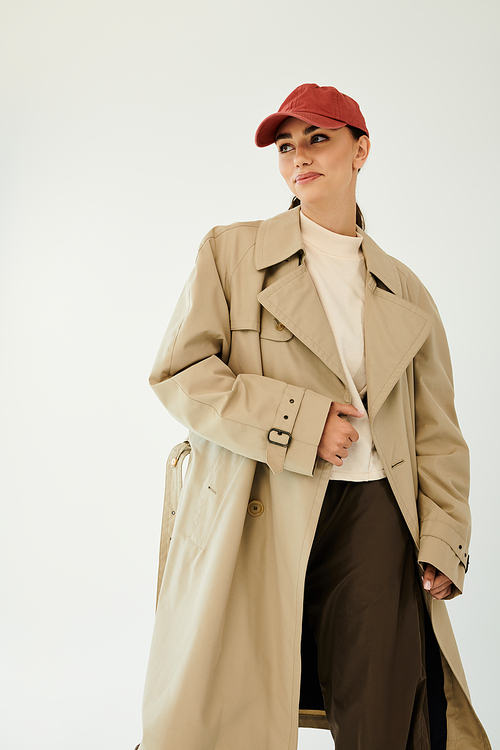 A young woman confidently poses in a chic autumn outfit, embodying seasonal elegance in a stylish studio backdrop.