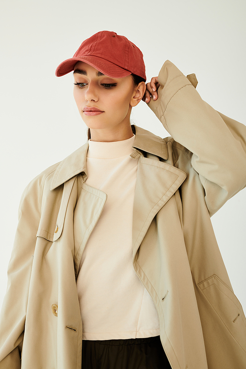 A young woman poses confidently in a chic autumn ensemble, capturing the essence of fall fashion in a tranquil studio space.