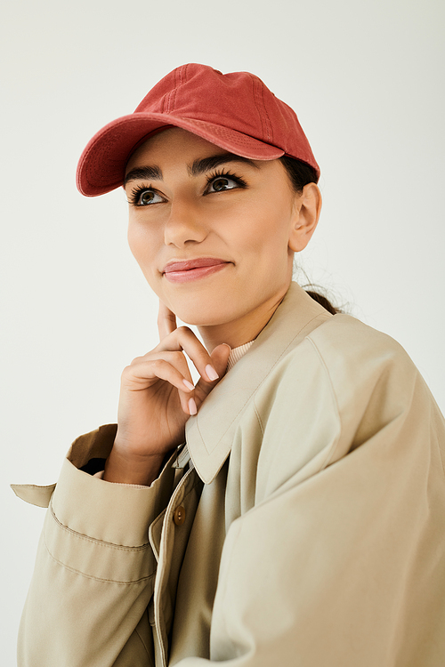 A young woman poses gracefully in a chic autumn outfit, bringing warmth and style to a studio setting filled with charm.