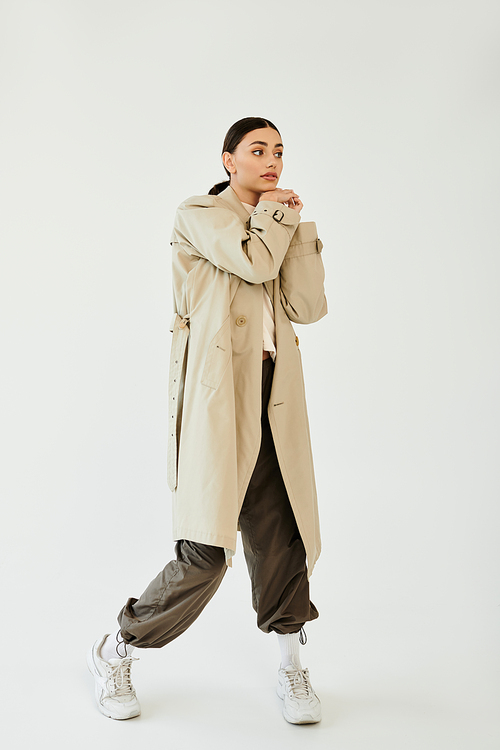 With confidence and flair, a young woman poses in a chic autumn ensemble that embodies the seasonal style.