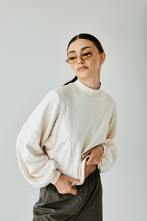 A fashionable young woman poses elegantly in a chic autumn outfit, capturing the essence of seasonal style in a studio.