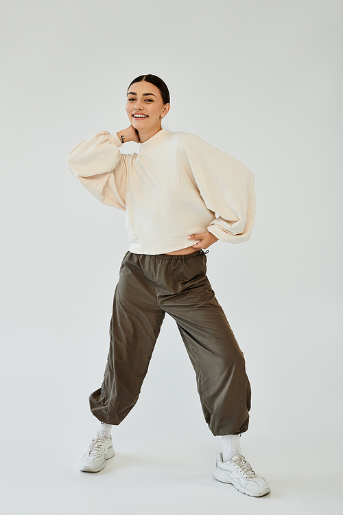 In a vibrant studio, a young woman radiates confidence while showcasing her chic autumn ensemble.