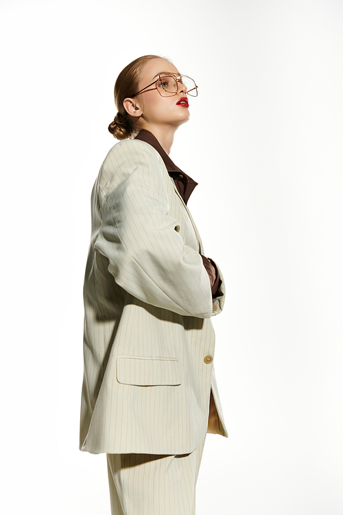 A young woman poses in a stylish white suit.