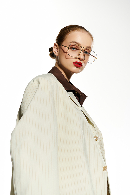 Young woman in white blazer confidently gazes at camera.