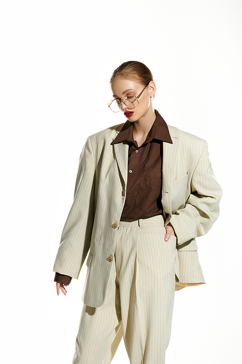 A young woman in a cream suit stands confidently with her hand in her pocket.