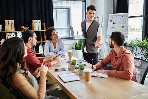 Colleagues converse in a modern setting during their work.