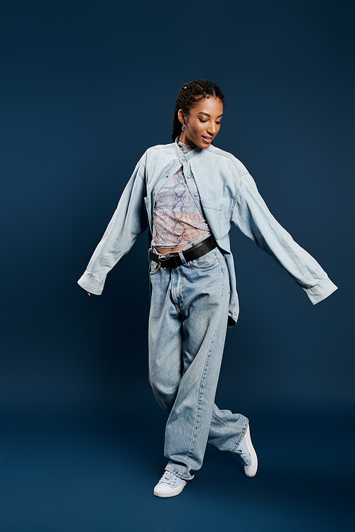 In a moment of elegance, a young woman twirls playfully, dressed in a chic denim outfit.