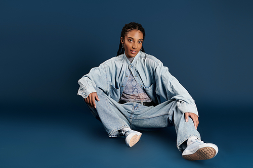 A confident young woman sits comfortably, displaying her unique fashion style.