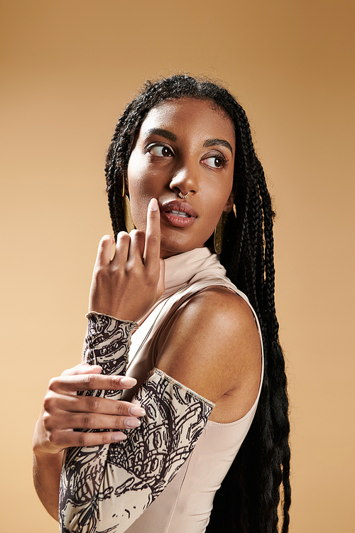 A stylish young woman poses gracefully, showcasing her unique attire against a warm backdrop.