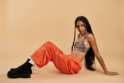 A fashionable young woman showcases her unique style while seated on the ground.