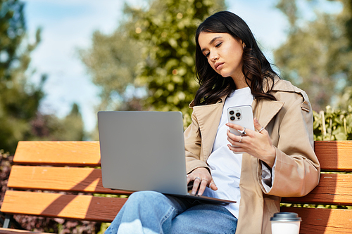 A young woman in warm attire immerses herself in work on a sunny autumn day outdoors.