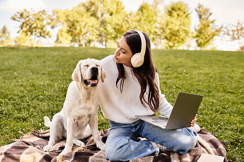 A young woman in cozy attire connects with her dog while working outdoors on a pleasant autumn day.