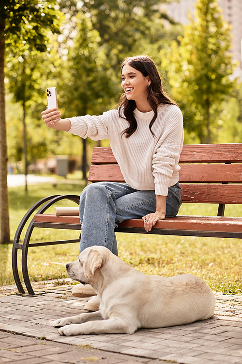 A cheerful woman enjoys a delightful moment, capturing a selfie with her loyal dog in the park.