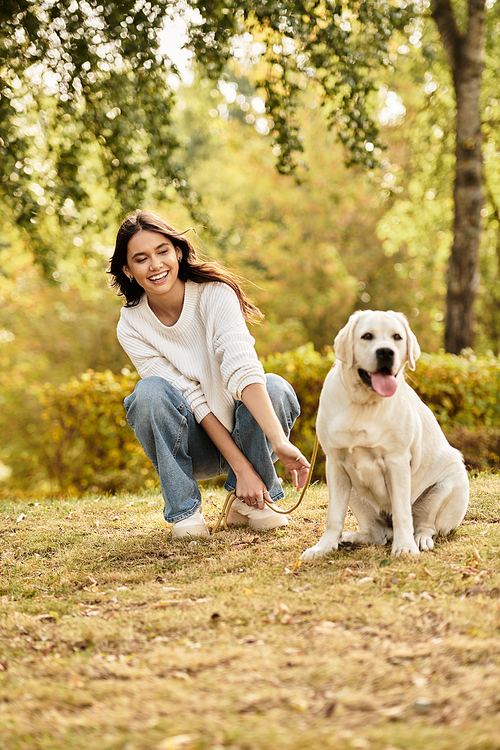 A young woman in cozy attire smiles warmly while enjoying a peaceful moment with her dog.