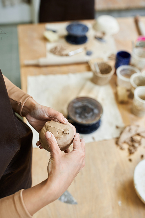 Talented woman with accessories and apron making pottery.