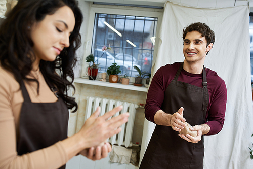 A loving couple enjoys creating pottery in a contemporary workspace.