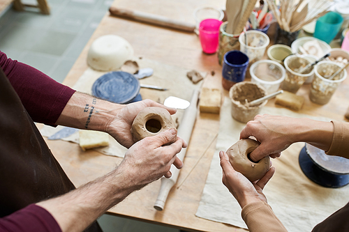 A couple joyfully crafting pottery in a creative workspace.