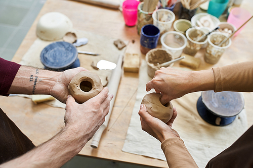 A couple joyfully molds clay into art in their vibrant pottery studio.