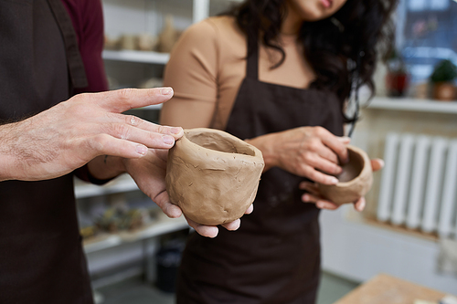 A couple joyfully shapes pottery in a contemporary studio environment.