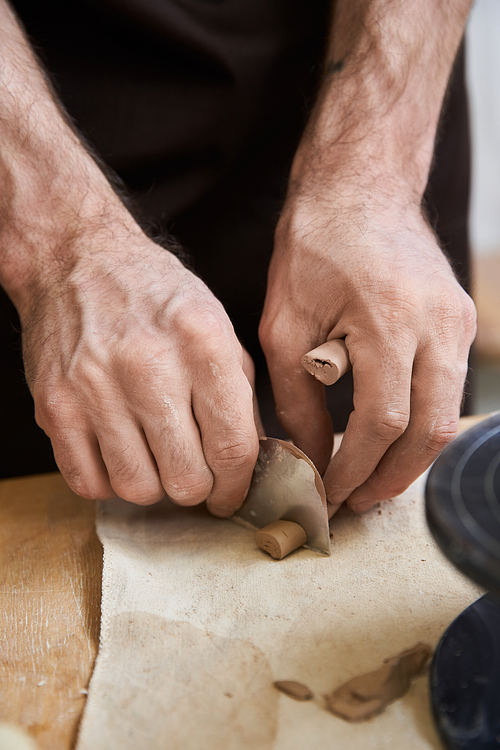 Hard working male in apron making some pottery in studio.