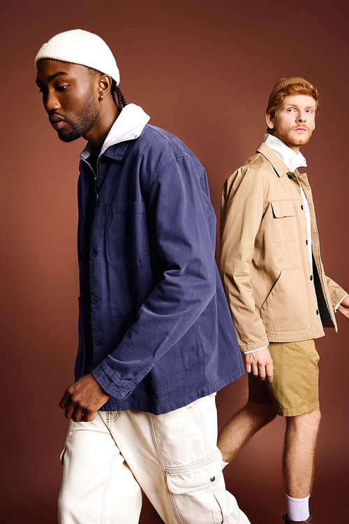 Two stylish men in jackets and shorts leisurely walking together.