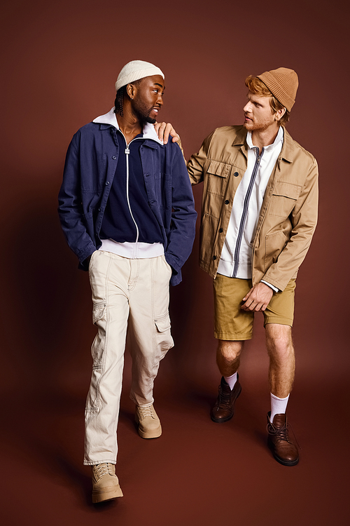 Two stylish young men of different backgrounds posing together.