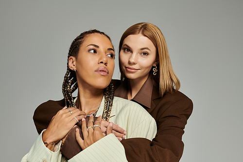 Two young women in cozy autumn clothing share a tender moment of affection and style.