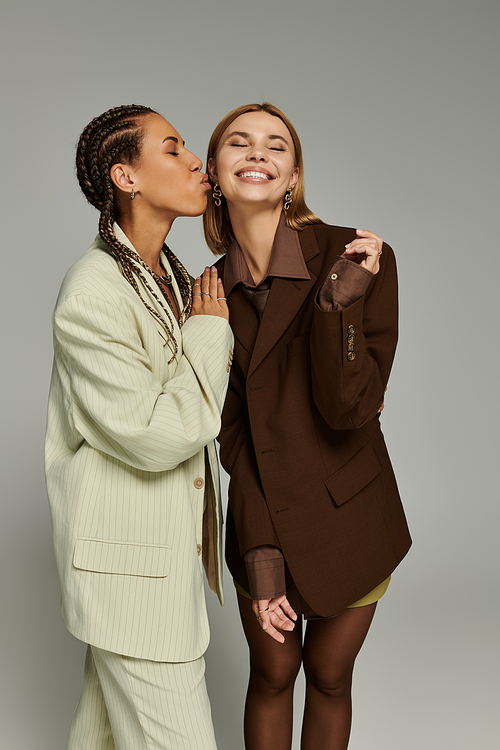 A cheerful lesbian couple dresses in stylish autumn outfits, sharing a loving moment.